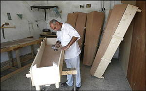 Coffin maker Abbas Hussein Mohammed opened a new shop in Baghdad to cope with rising demand. Last month the capital's morgue received 1,536 victims of violence. Photo Credit: By Khalid Mohammed -- Associated Press